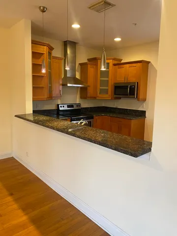 a kitchen with stainless steel appliances granite countertop a sink a stove and a refrigerator