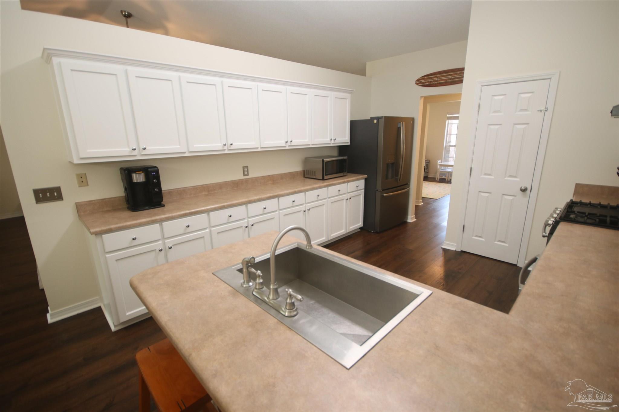 4930 Chads Circle Milton, FL 32571 - Photo 12 of 50 a kitchen with stainless steel appliances granite countertop a sink a stove and white cabinets