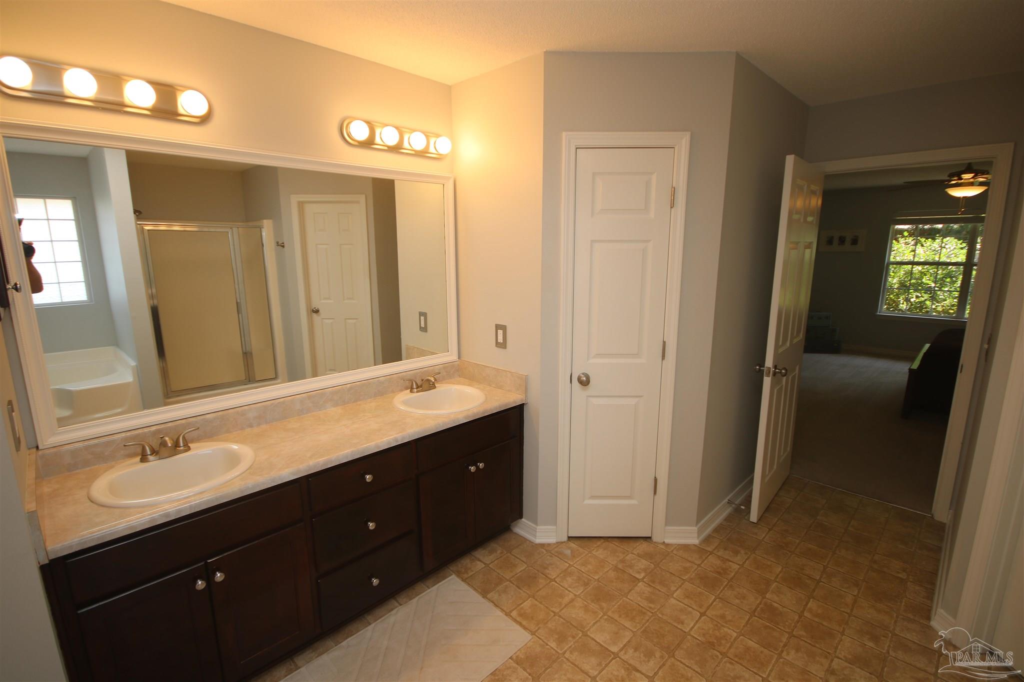 4930 Chads Circle Milton, FL 32571 - Photo 31 of 50 a spacious bathroom with a double vanity sink and a mirror