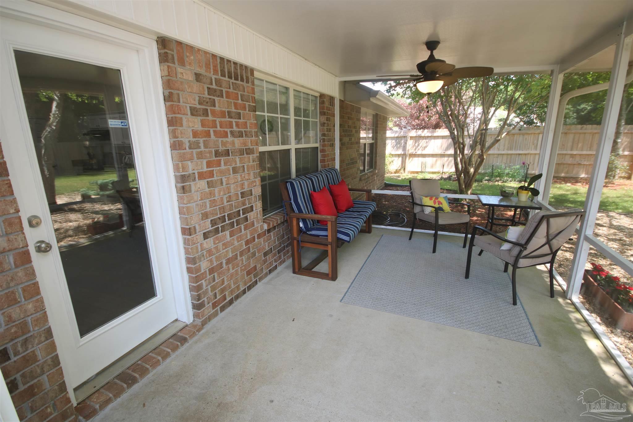 4930 Chads Circle Milton, FL 32571 - Photo 6 of 50 a living room with furniture a flat screen tv and a floor to ceiling window