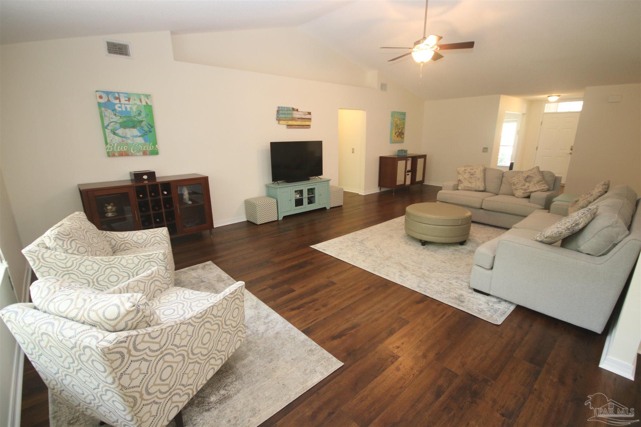 4930 Chads Circle Milton, FL 32571 - Photo 9 of 50 a living room with furniture a flat screen tv and kitchen view