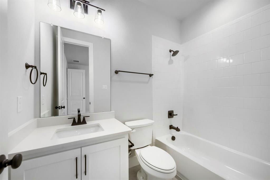799 Mandrake Road Haslet, TX 76052 - Photo 14 of 27 a bathroom with a bathtub shower sink vanity mirror and toilet