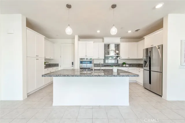 a kitchen with kitchen island a counter top stainless steel appliances and cabinets