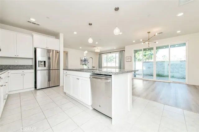 a kitchen with stainless steel appliances granite countertop a refrigerator and a sink