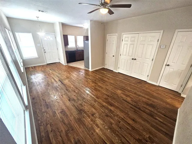 a view of a livingroom with wooden floor and a ceiling fan