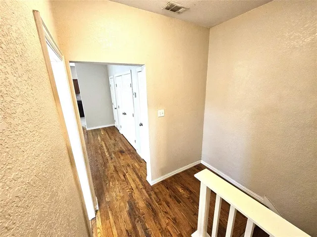a view of a hallway with wooden floor and entryway