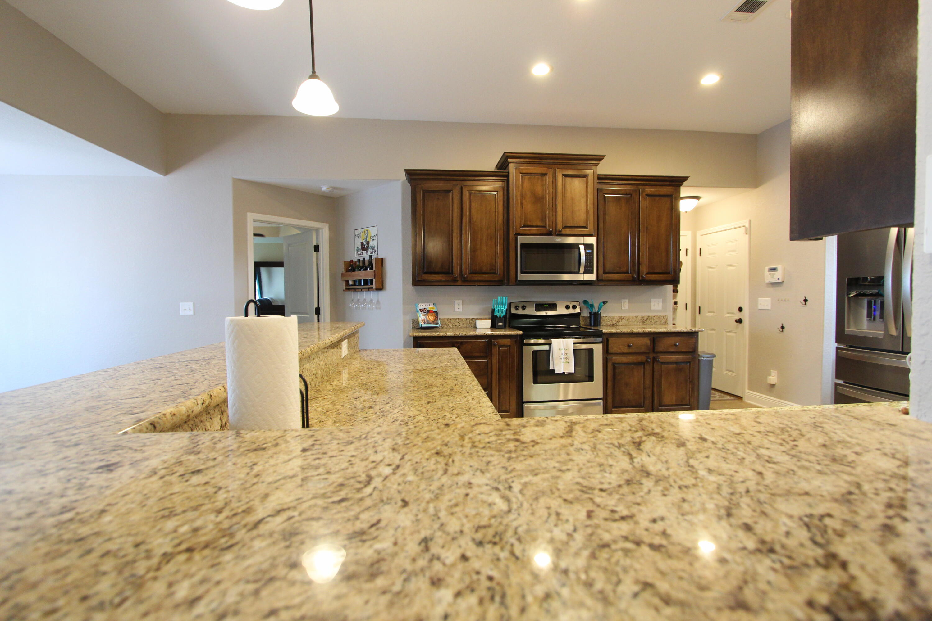 502 Vale Loop Crestview, FL 32536 - Photo 11 of 53 a kitchen with granite countertop a stove a sink and a refrigerator