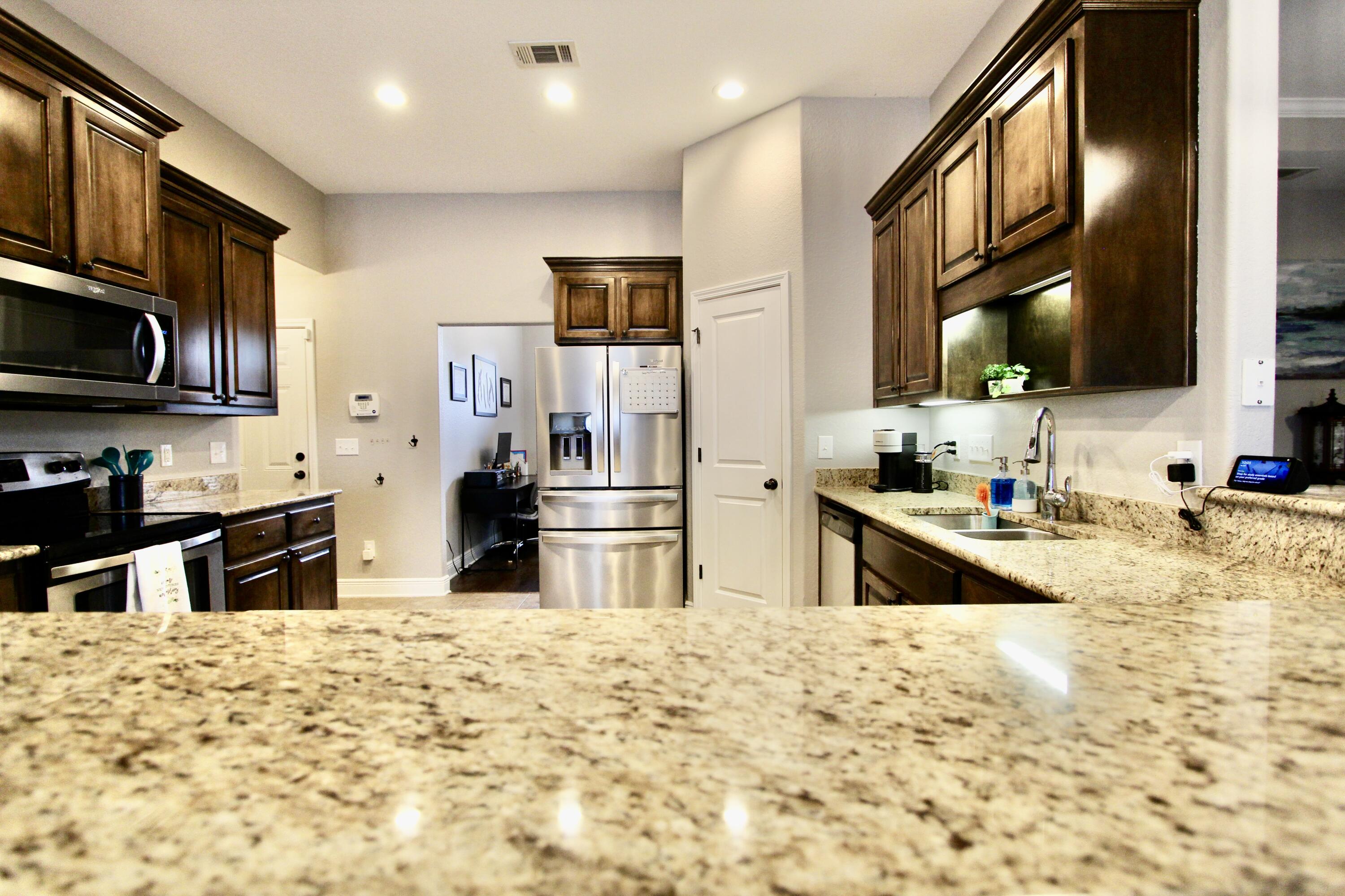 502 Vale Loop Crestview, FL 32536 - Photo 14 of 53 a kitchen with stainless steel appliances kitchen island granite countertop a refrigerator and a stove top oven