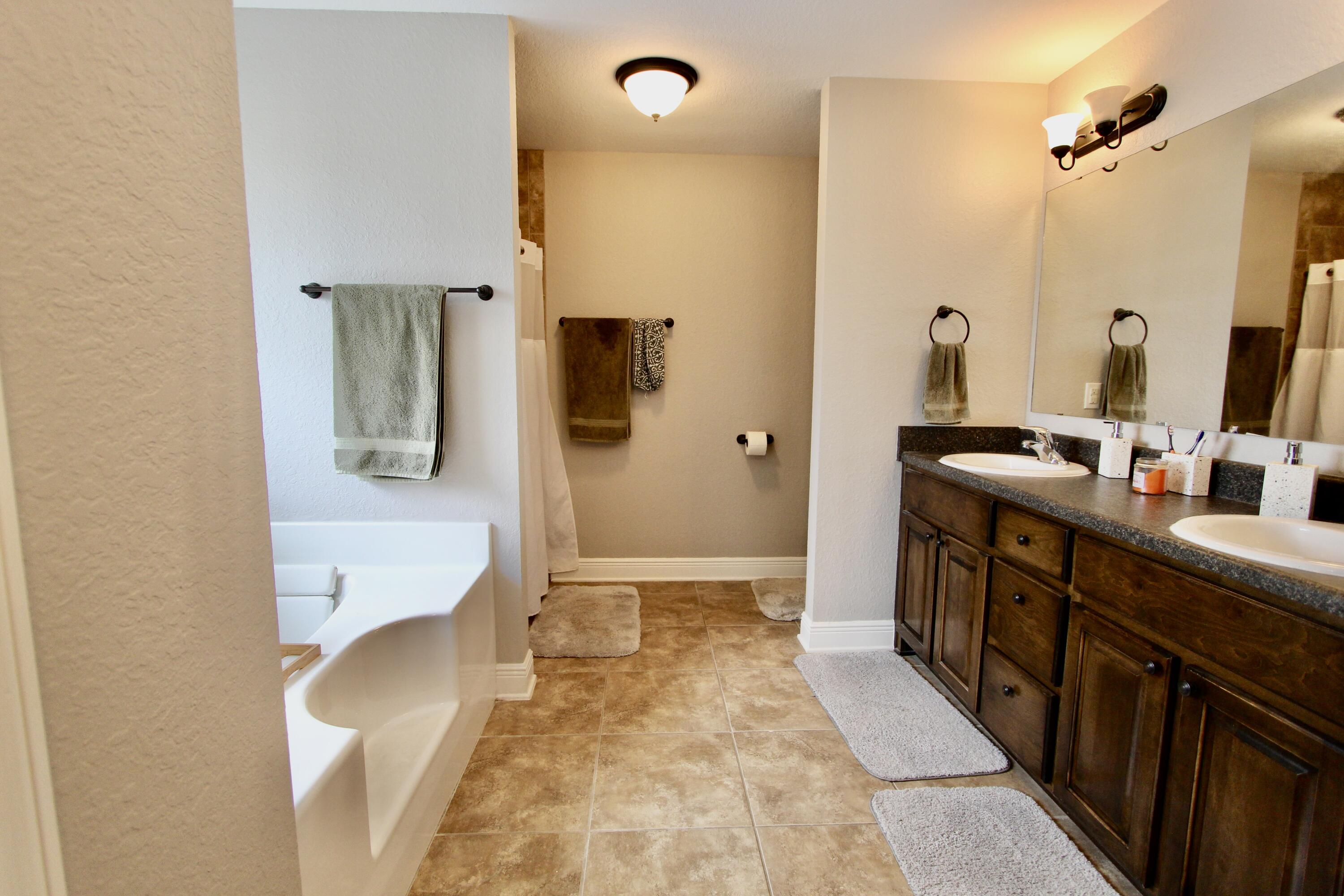 502 Vale Loop Crestview, FL 32536 - Photo 40 of 53 a bathroom with a double vanity sink a mirror and a shower
