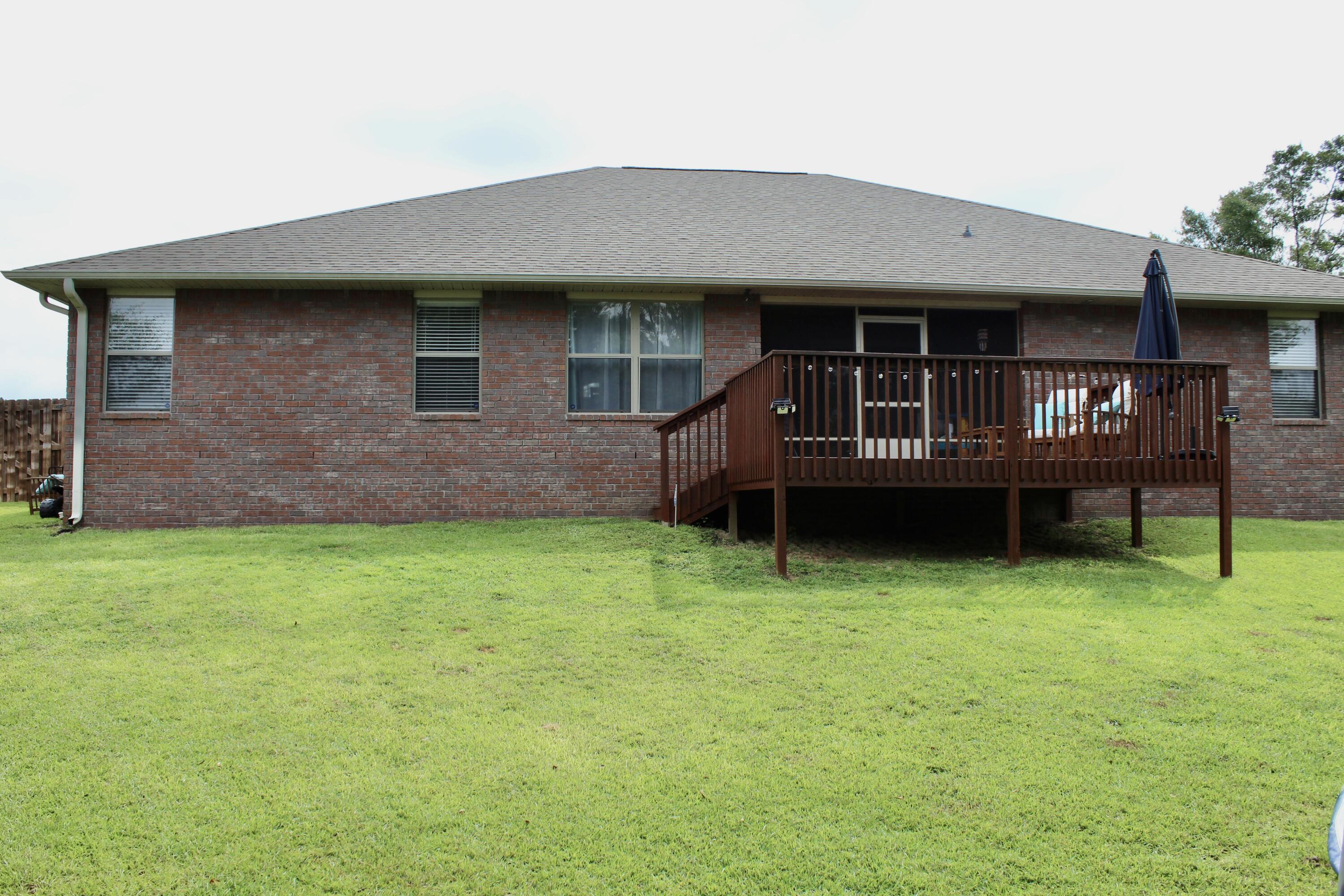 502 Vale Loop Crestview, FL 32536 - Photo 49 of 53 a backyard of a house with lawn chairs and a barbeque