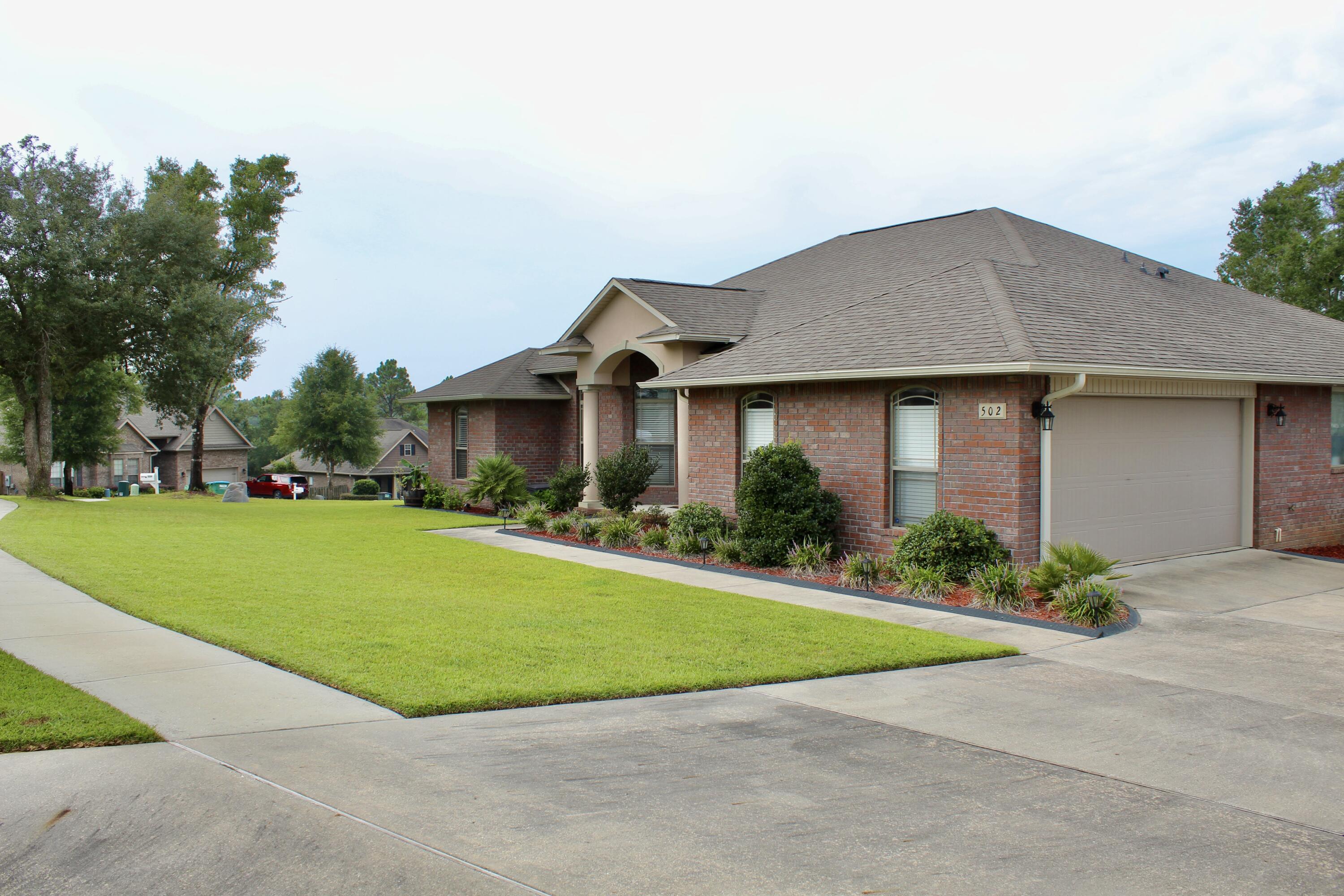 502 Vale Loop Crestview, FL 32536 - Photo 6 of 53 a front view of a house with a garden and yard