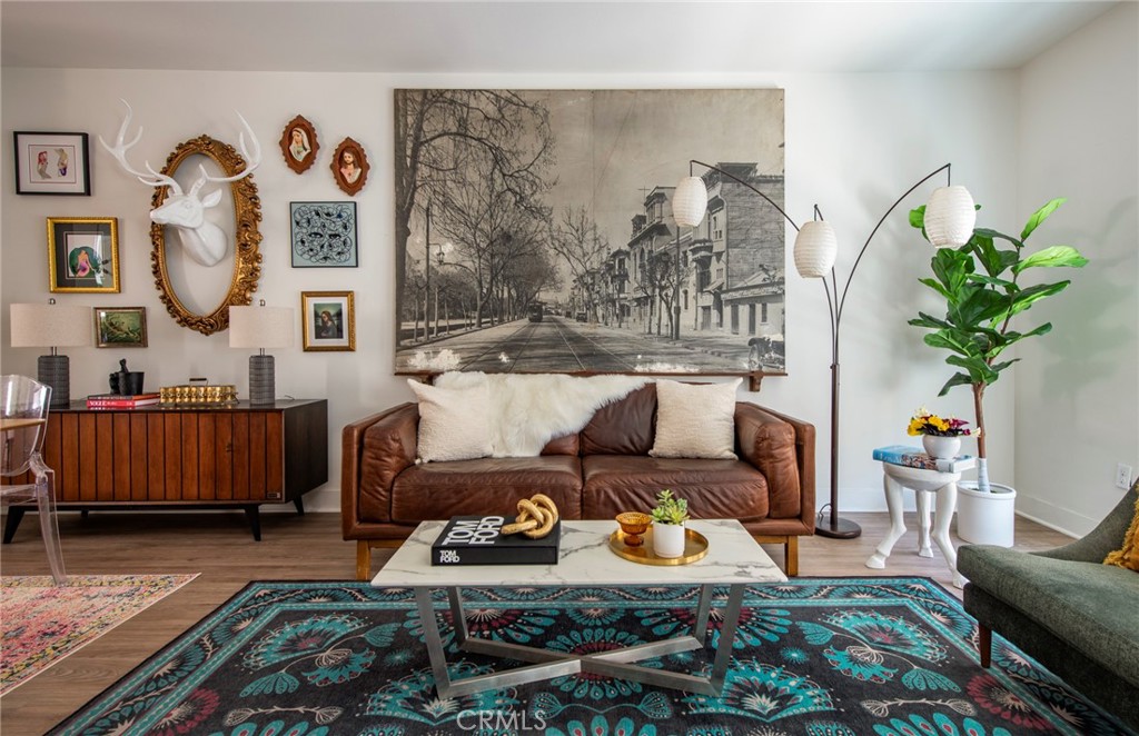 a living room with furniture a rug and wall paintings