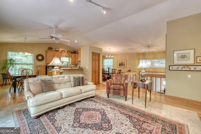 a view of a dining room with furniture a chandelier and wooden floor