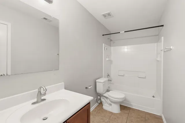 a bathroom with a toilet sink vanity and shower