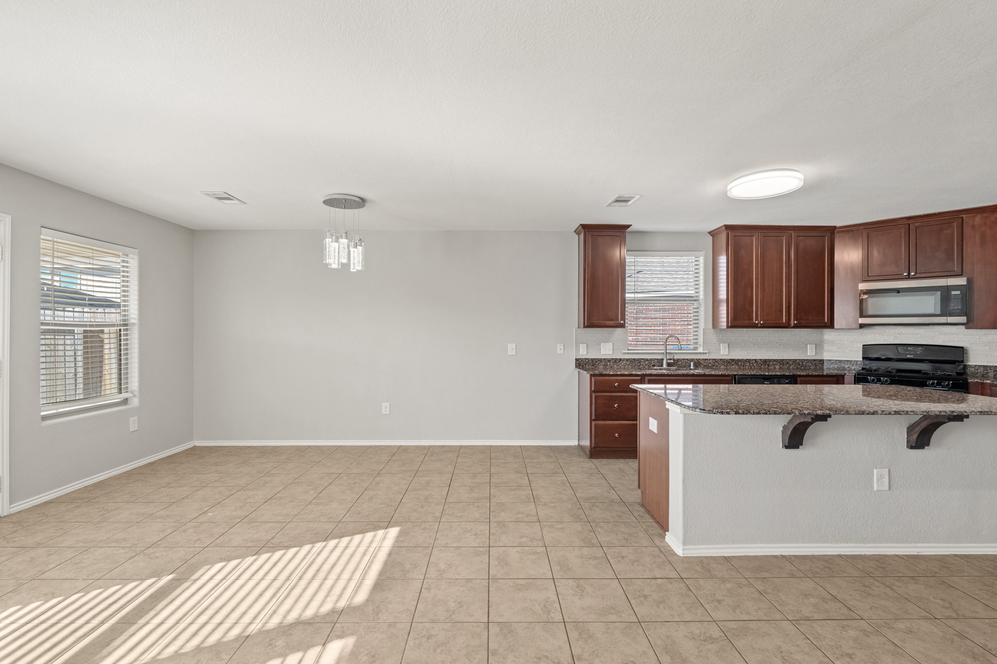 21359 Bandera Ranch Lane Katy, TX 77449 - Photo 10 of 31 a kitchen with stainless steel appliances granite countertop a stove a sink and a microwave