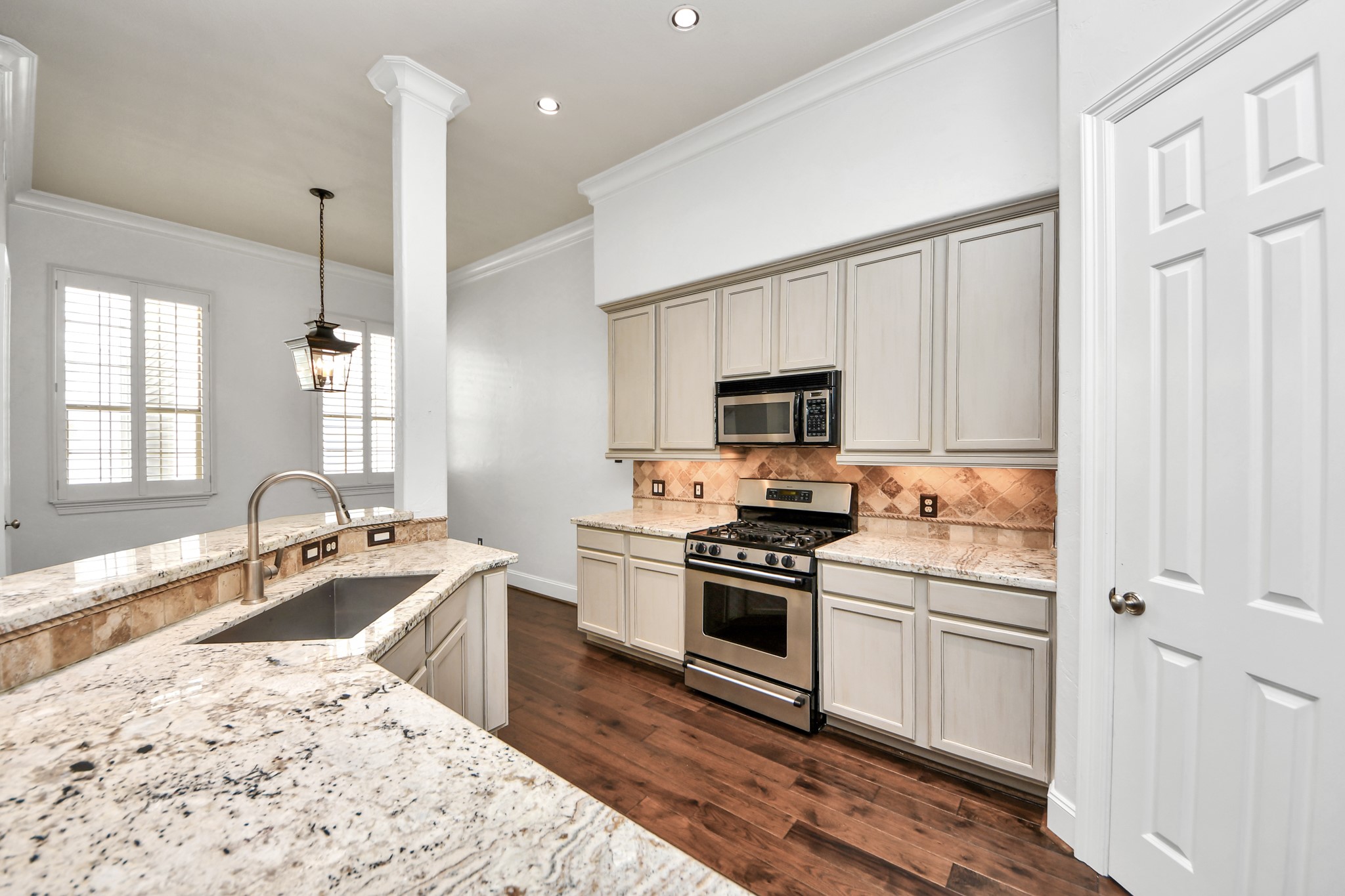 710 Jackson Hill Street Houston, TX 77007 - Photo 11 of 31 This kitchen features elegant granite countertops, stainless steel appliances, and light cabinetry. The open layout includes a breakfast bar and ample natural light, creating a bright, welcoming space.