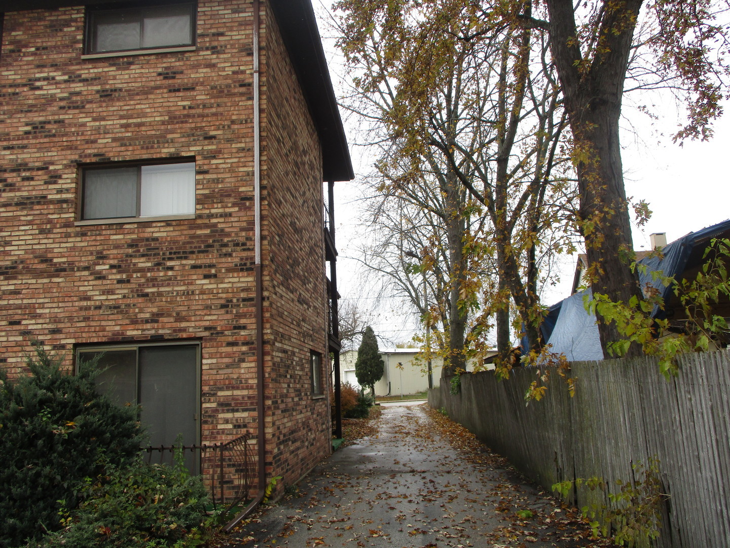 18405 Wentworth Avenue, Unit 1D Lansing, IL 60438 - Photo 3 of 6 a brick building with a bench next to a road