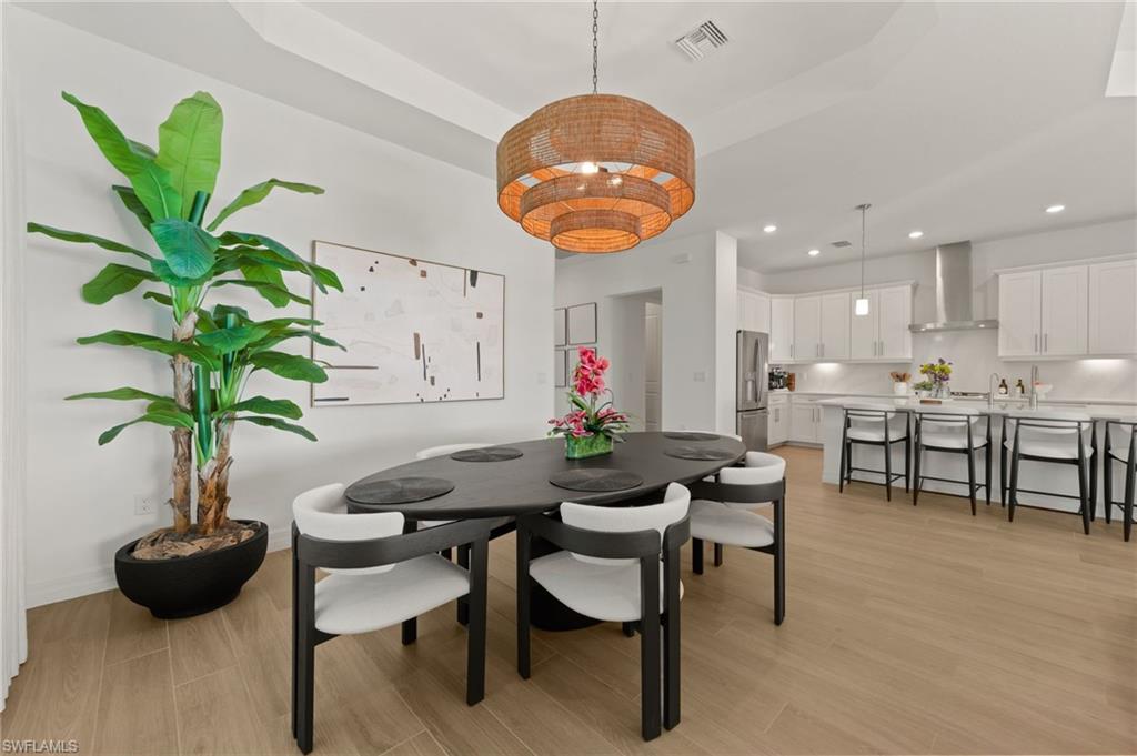 13654 Blue Bay Circle Fort Myers, FL 33913 - Photo 12 of 50 a view of a dining room with furniture and wooden floor