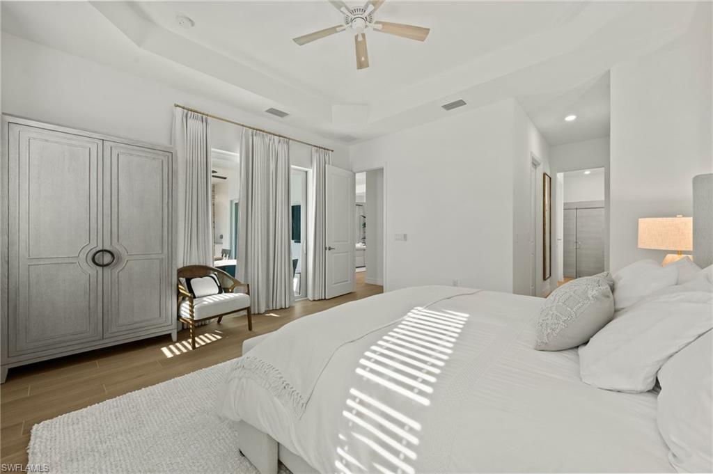 13654 Blue Bay Circle Fort Myers, FL 33913 - Photo 18 of 50 a bedroom with a bed and a chandelier