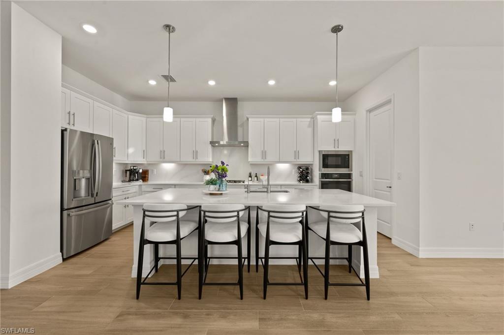 13654 Blue Bay Circle Fort Myers, FL 33913 - Photo 8 of 50 a kitchen with stainless steel appliances granite countertop a dining table chairs refrigerator and microwave