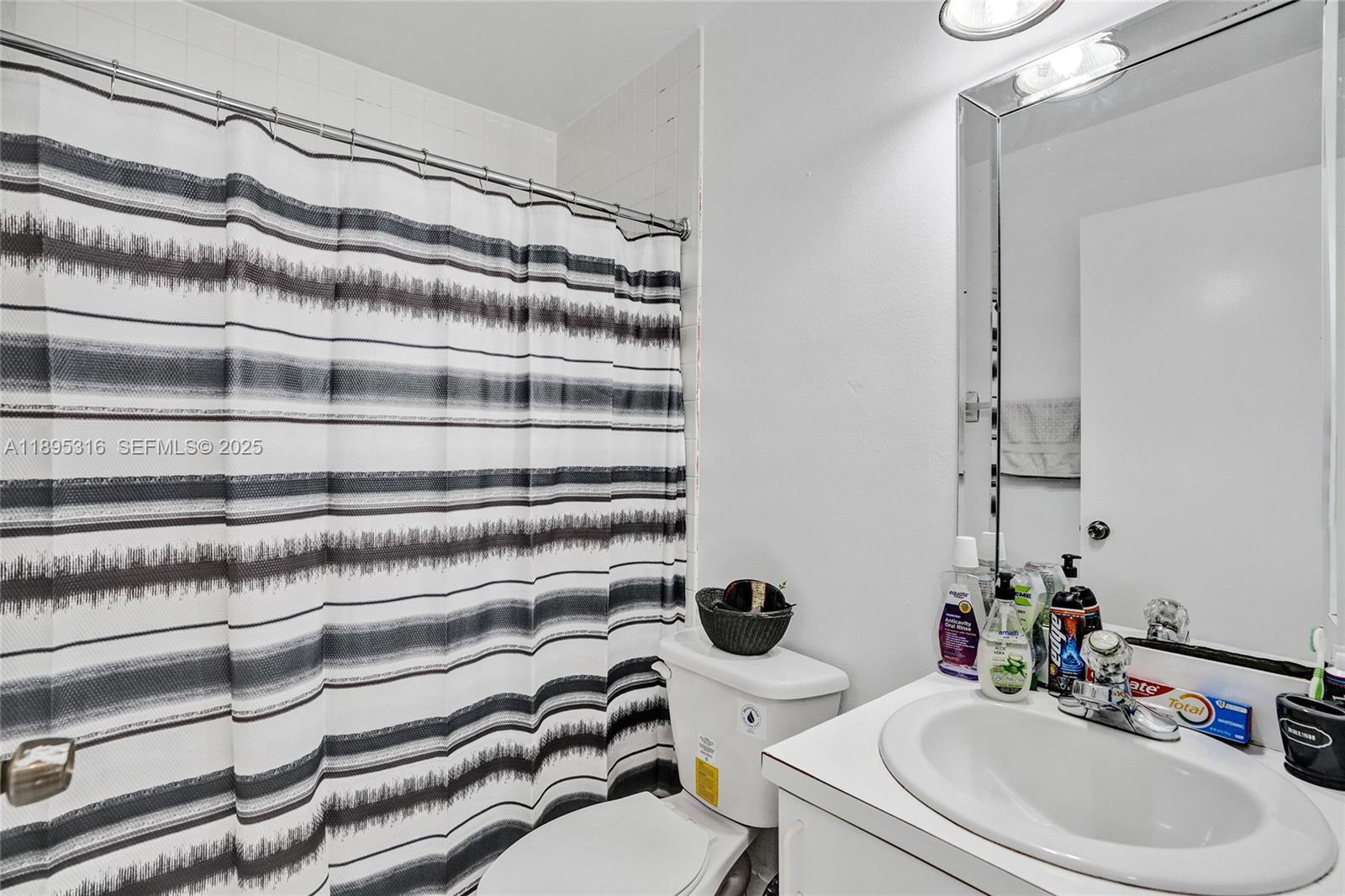13780 Southwest 160th Terrace Miami, FL 33177 - Photo 31 of 42 a bathroom with a sink a toilet and shower curtain