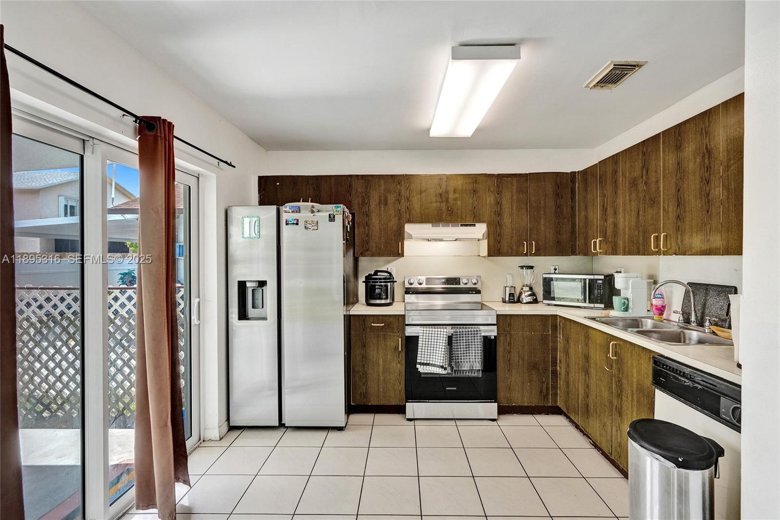 13780 Southwest 160th Terrace Miami, FL 33177 - Photo 7 of 42 a kitchen with a sink a refrigerator and cabinets