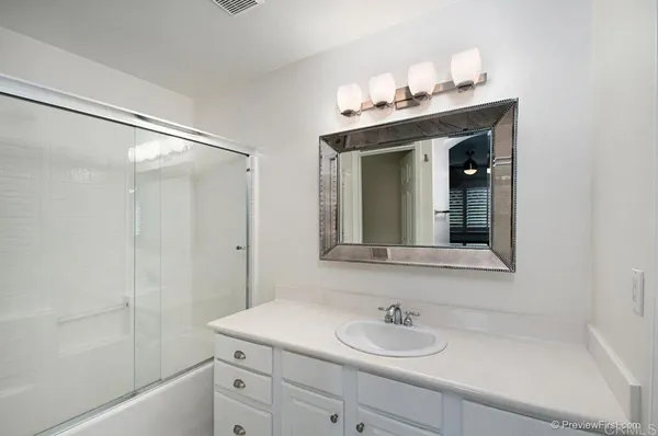 a bathroom with a sink vanity granite tub and shower