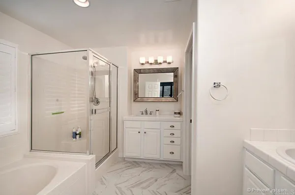 a spacious bathroom with a shower sink and mirror