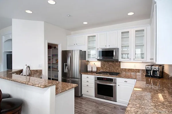 a kitchen with stainless steel appliances granite countertop a stove a sink and a refrigerator