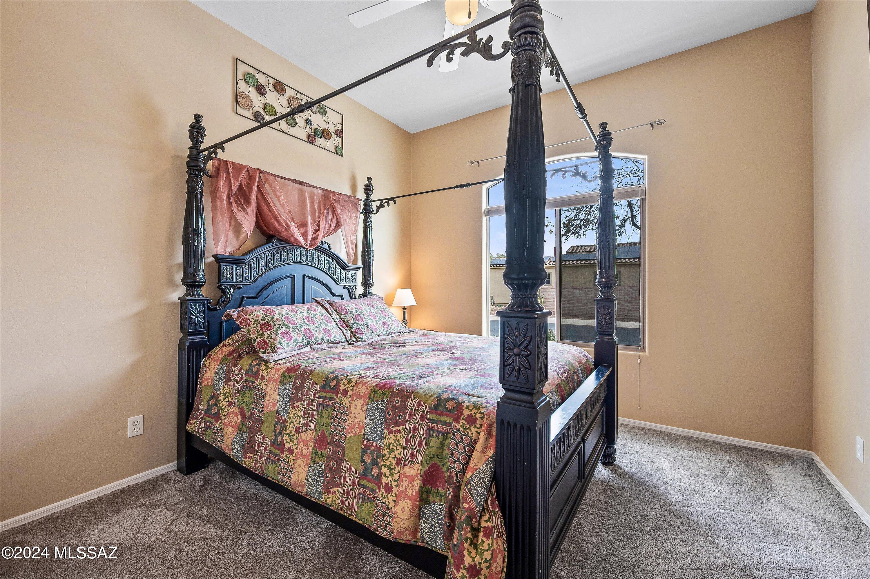 8579 North Shadow Wash Way Tucson, AZ 85743 - Photo 14 of 34 a bedroom with a bed and a chandelier