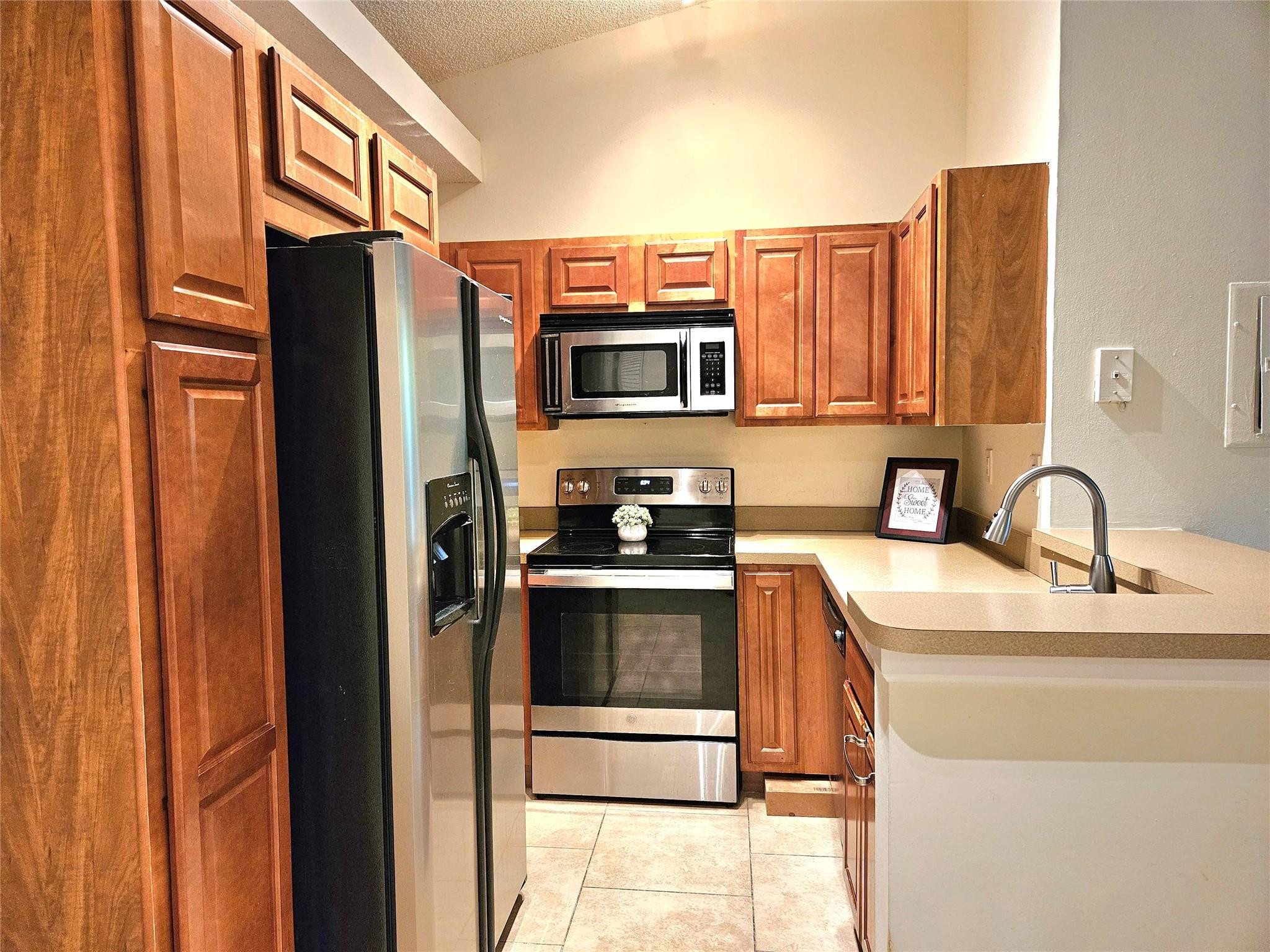 a kitchen with stainless steel appliances granite countertop a refrigerator and a sink