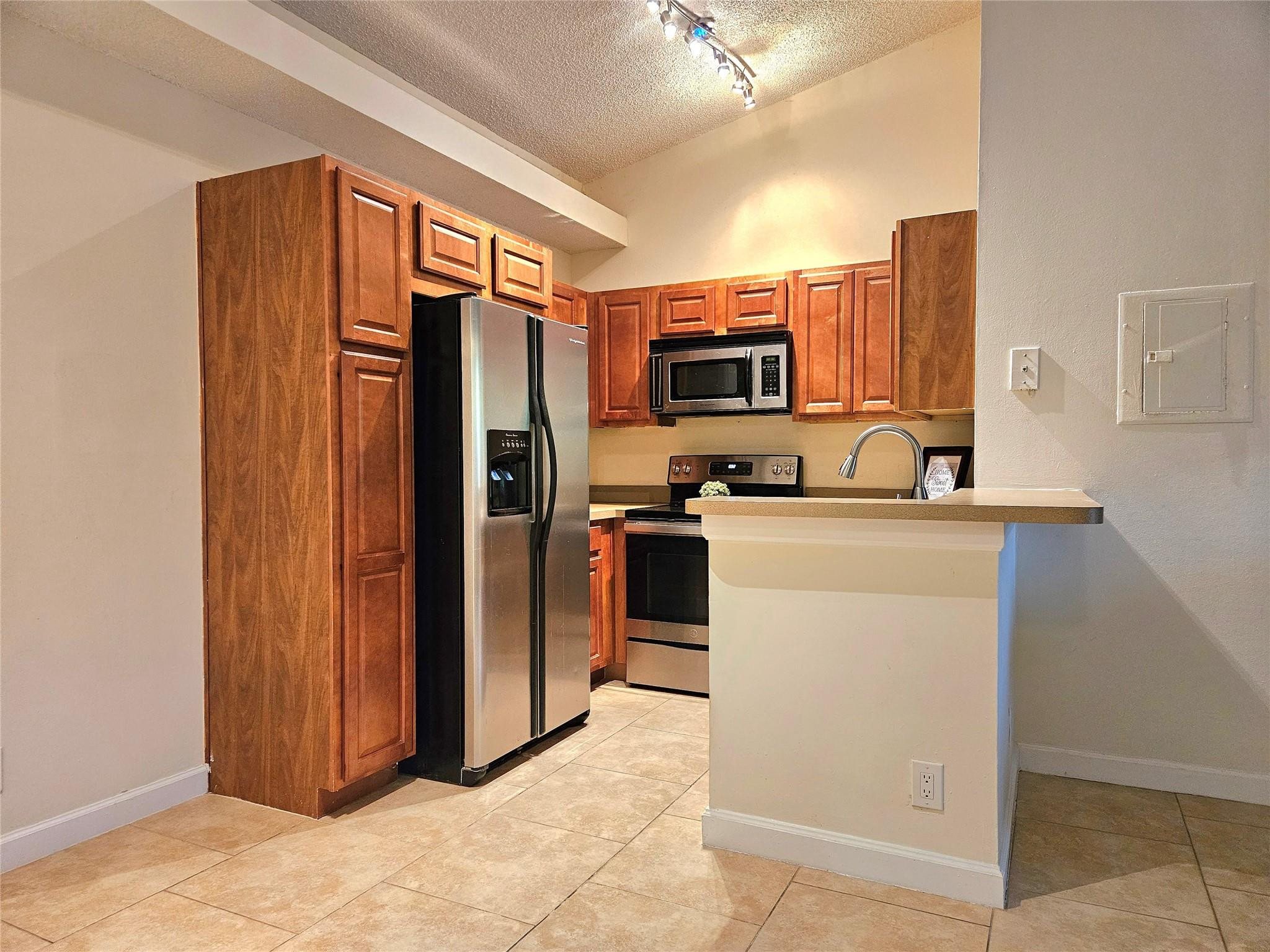701 Lyons Road, Unit 13205 Coconut Creek, FL 33063 - Photo 3 of 37 a kitchen with stainless steel appliances a refrigerator and a stove top oven