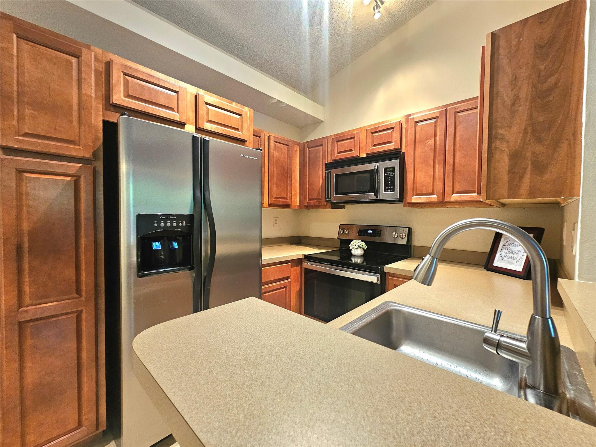 701 Lyons Road, Unit 13205 Coconut Creek, FL 33063 - Photo 4 of 37 a kitchen with stainless steel appliances granite countertop a refrigerator and a stove top oven