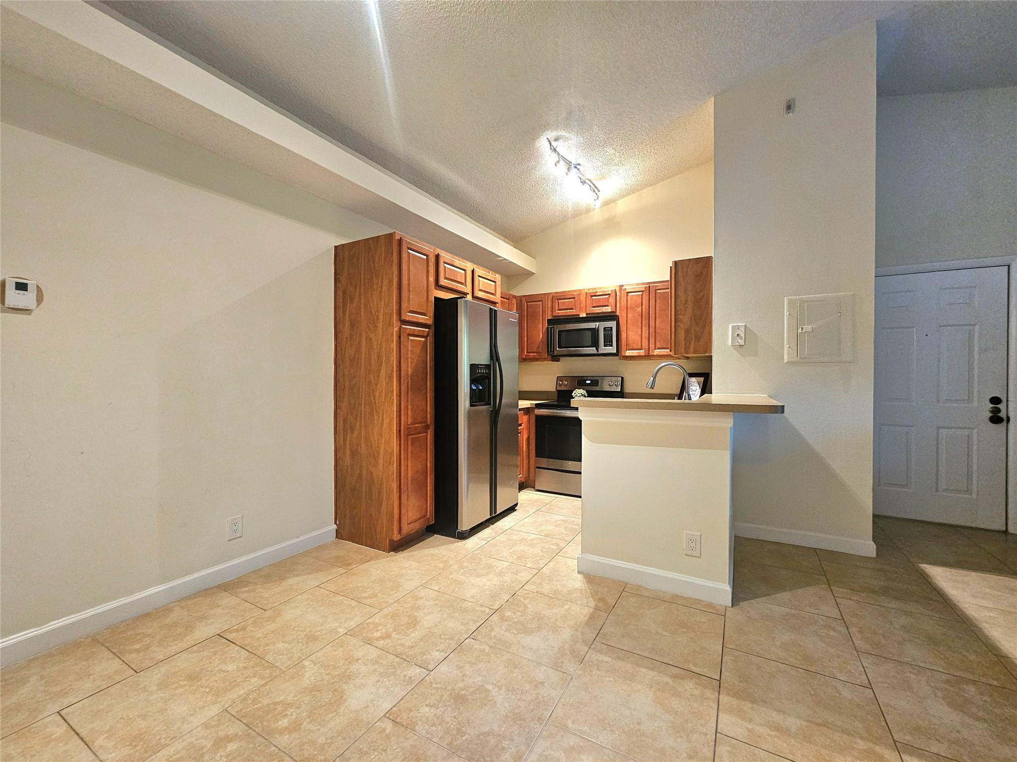 701 Lyons Road, Unit 13205 Coconut Creek, FL 33063 - Photo 8 of 37 a kitchen with refrigerator and cabinets