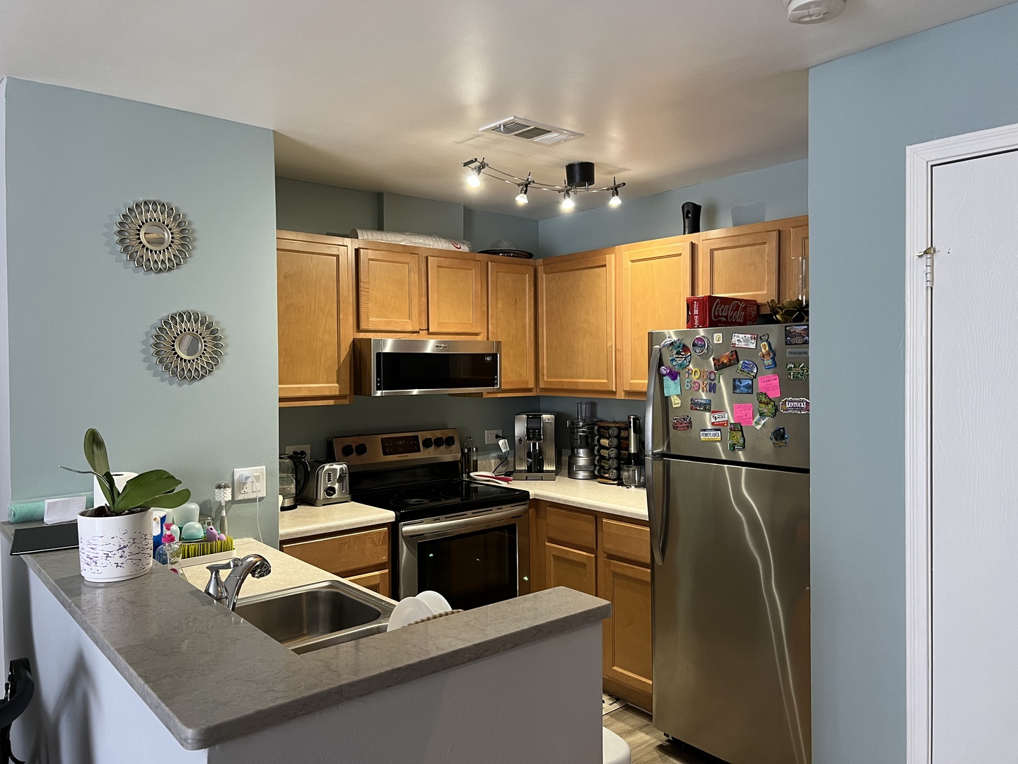 1931 North Hicks Road, Unit 211 Palatine, IL 60074 - Photo 5 of 18 a kitchen with stainless steel appliances granite countertop a sink dishwasher stove and refrigerator with wooden floor