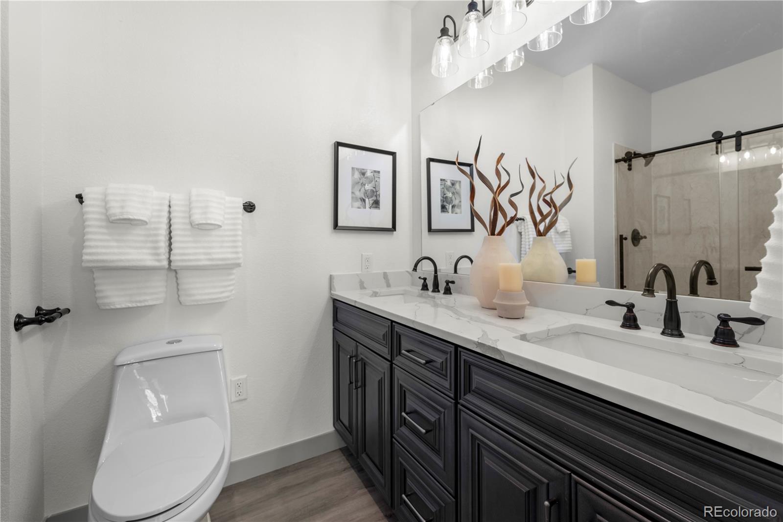 18645 Stroh Road, Unit 207 Parker, CO 80134 - Photo 29 of 32 a bathroom with a double vanity sink mirror and toilet