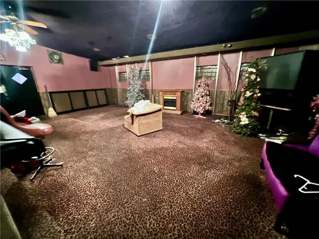 a living room with furniture a flat screen tv and a floor to ceiling window