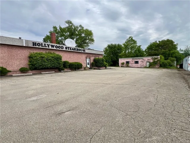front view of a house with a yard and potted plants