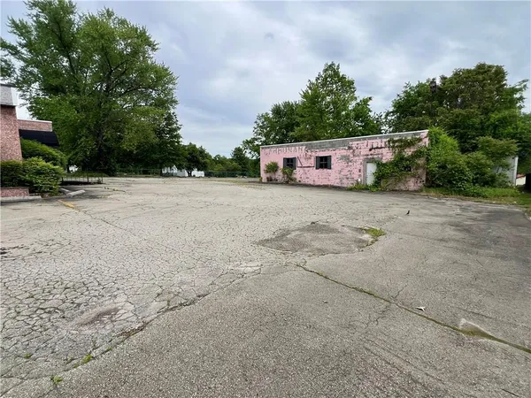 a dirt road with a building in the background