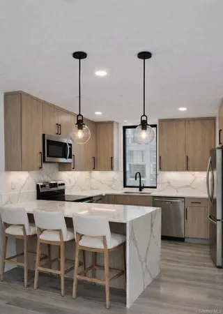 a kitchen with stainless steel appliances granite countertop a sink a stove top oven a counter space and cabinets