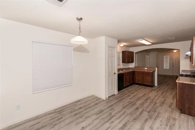 a large kitchen with a wooden floor and stainless steel appliances