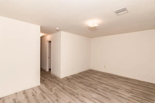 a view of a room with wooden floor and white walls
