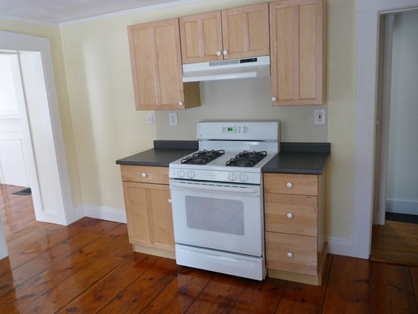 478-480 Gleasondale Road Stow, MA 01775 - Photo 8 of 10 a kitchen with granite countertop wooden cabinets and white appliances