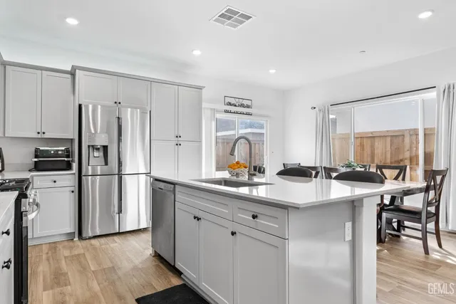 a kitchen with stainless steel appliances granite countertop a stove a sink and a refrigerator