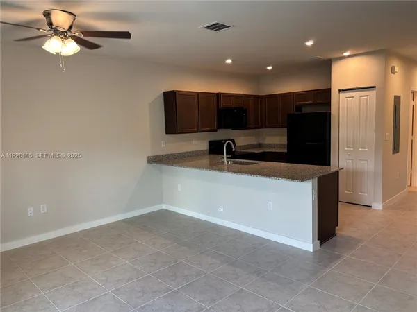 a kitchen with kitchen island a sink stainless steel appliances and a refrigerator