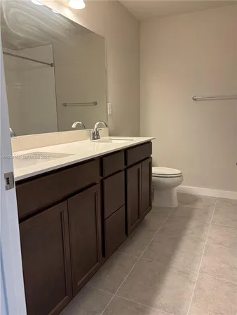a bathroom with a granite countertop toilet and a shower
