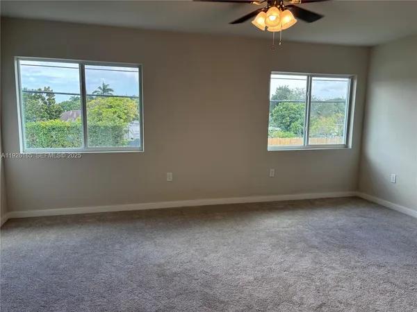 a view of a small space with a chandelier fan