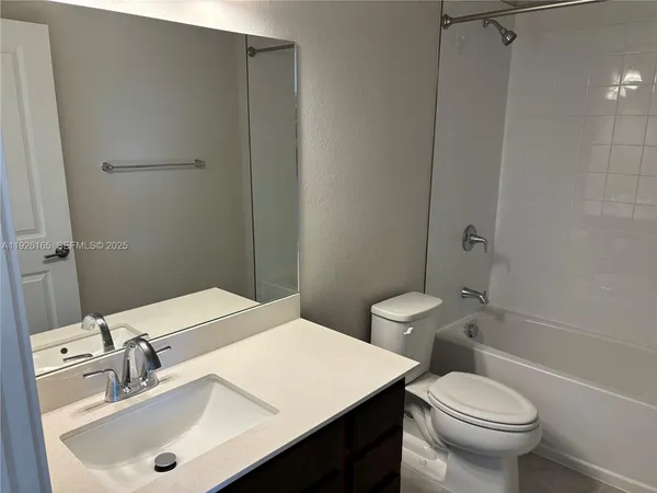 a kitchen with a sink and a stove top oven with wooden floor