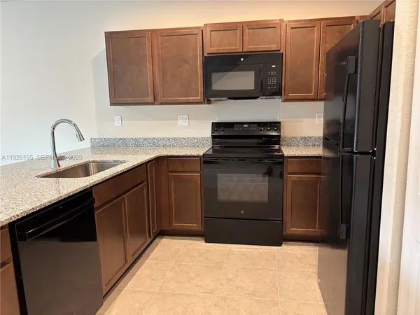 a kitchen with a sink granite counter tops and a window
