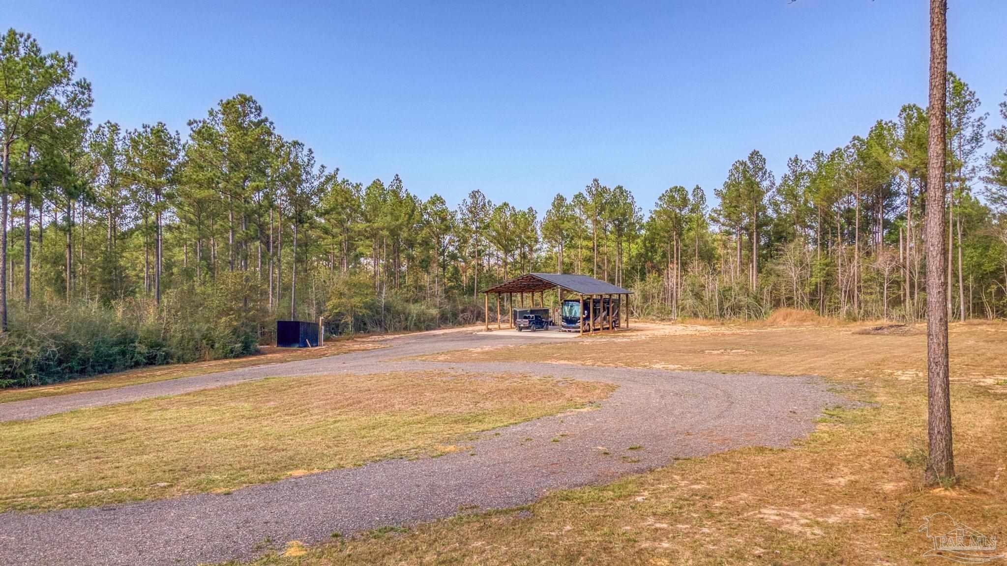 8030 Gin Road Milton, FL 32571 - Photo 4 of 13 a view of a yard with trees in the background